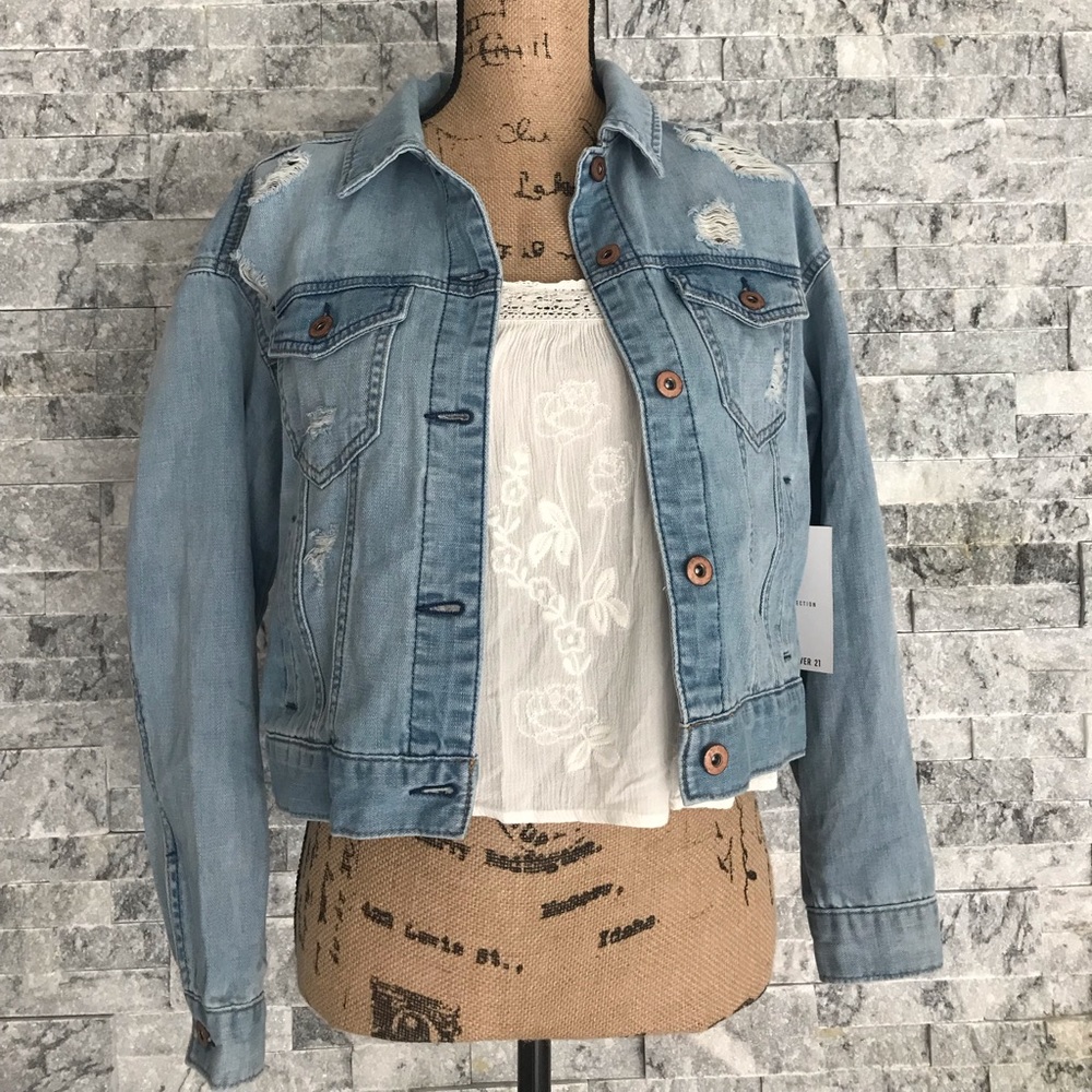 BNWT A cropped denim jacket featuring allover distressing, with pockets